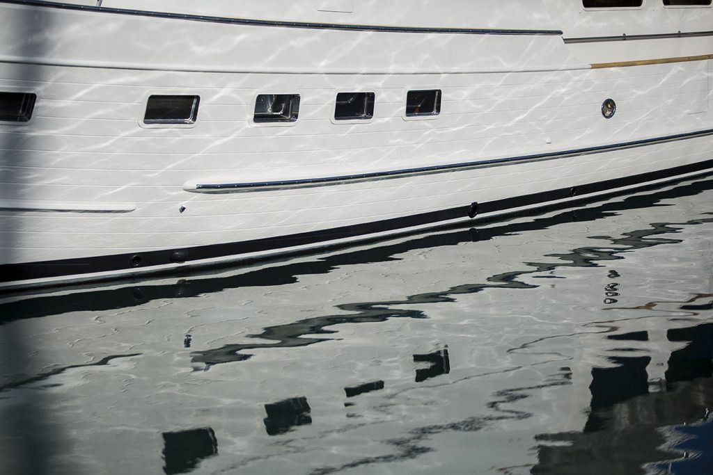 Closer up image of the side of a boat and the reflection at Coral Sea Marina