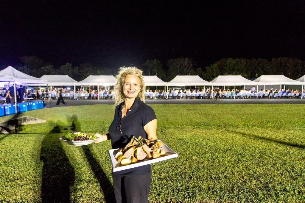 A waitress serving food at the Airlie Beach Runway Dinner 2019