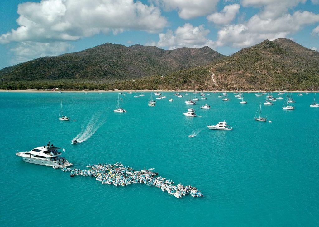 A flotilla of small vessels rafted up for the 2018 'Joining Hands across the Blue' event on the SICYC Rendezvous, Cape Gloucester