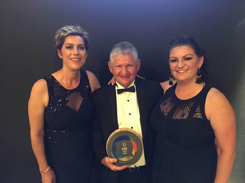 Staff members of Cumberland Yacht Charters holding their Gold Winner trophy at the 2019 Queensland Tourism Awards