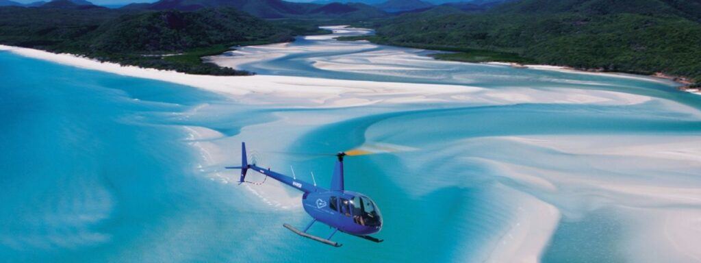 Helireef blue Helicopter flying over Hill Inlet at Whitehaven Beach