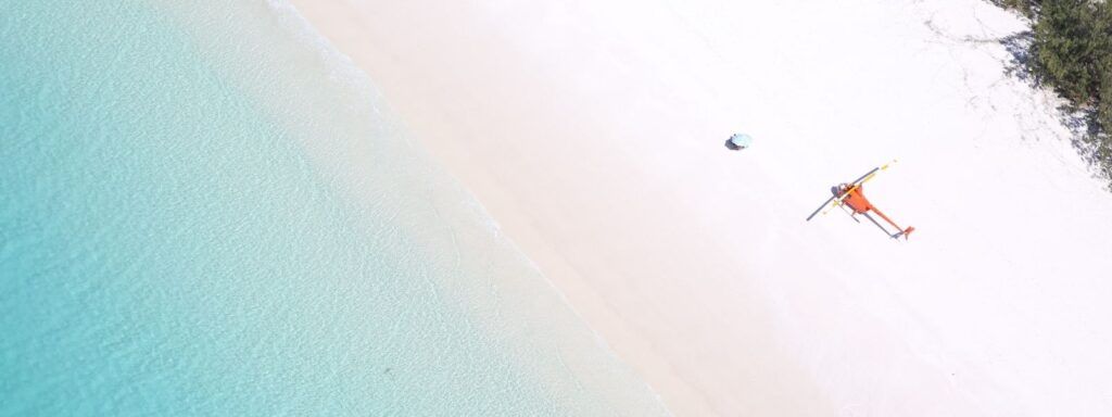 A helicopter at Whitehaven Beach with picnic Umbrella