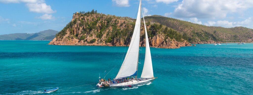 Sailing maxi yacht, British Defender, sailing in the Whitsundays on bright blue waters