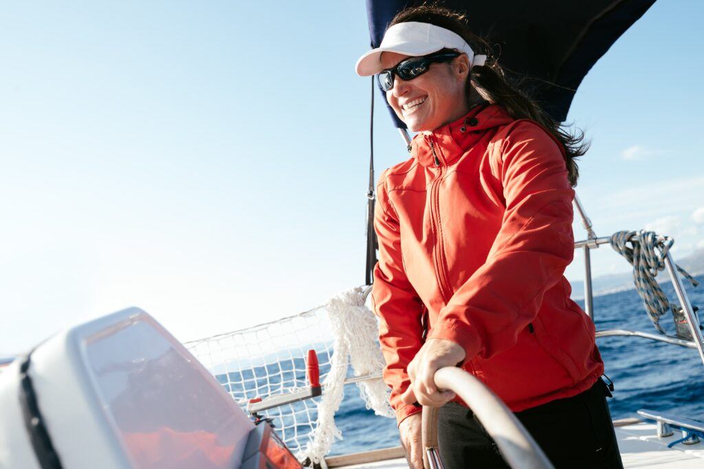 A woman at the helm of a sailing vessel